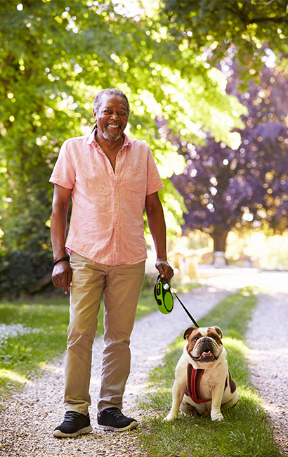 portrait of senior man walking with his dog in the park life insurance
