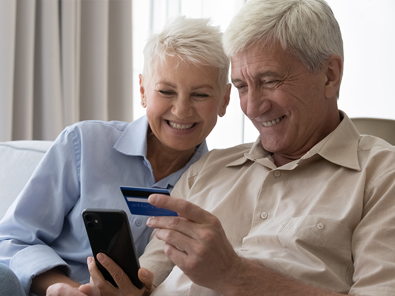 happy couple on phone with credit card life insurance options jb retirement strategies florida